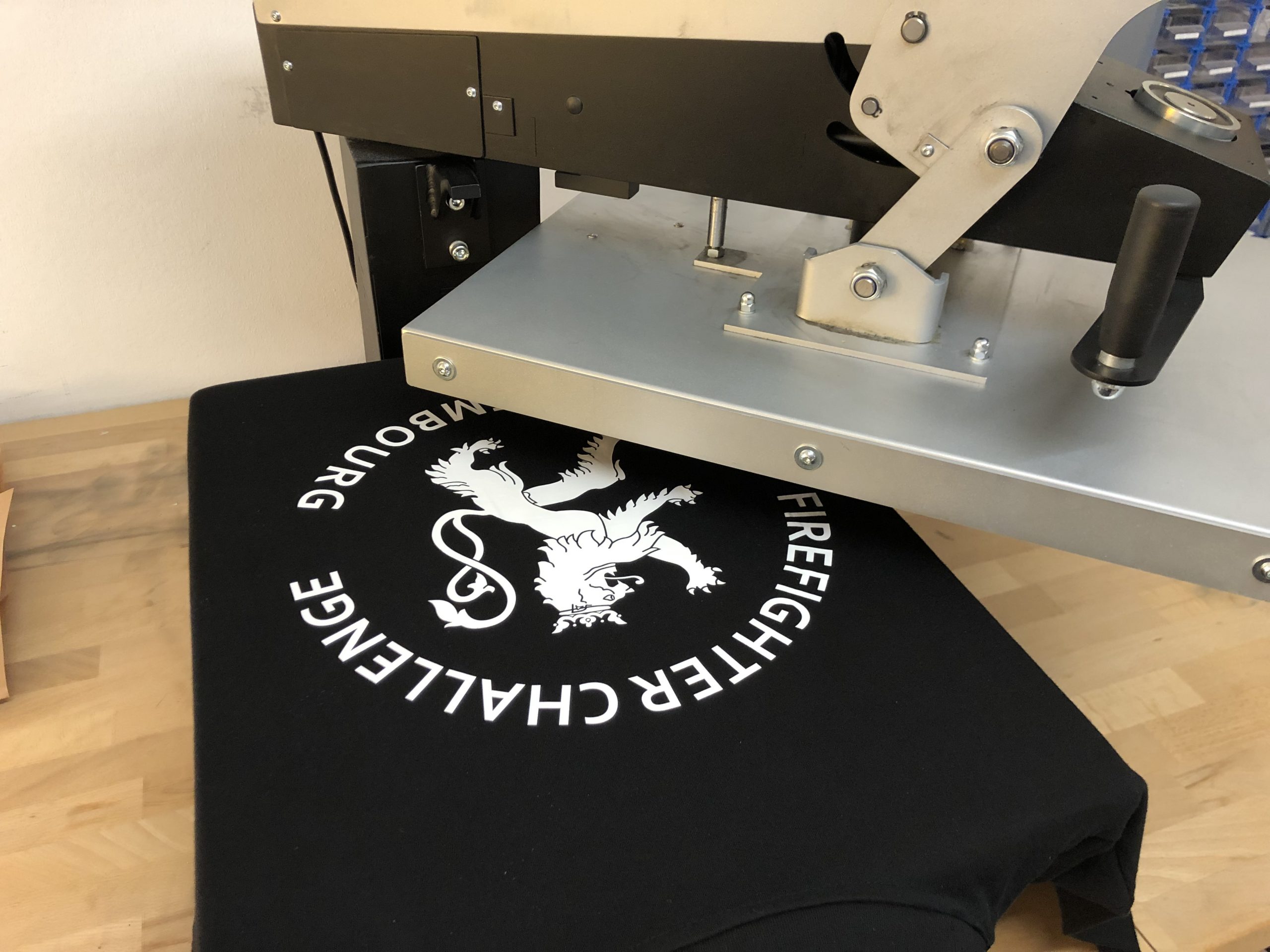 Transferpresse bei Evodruck während der Veredelung eines schwarzen T-Shirts